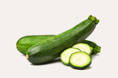 Fresh whole and sliced zucchini isolated on white background. From top view. Courgette zucchini cut into slices